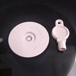 Dispensador mural de papel higiénico Täumm fabricado en acrílico transparente o de color, con cerradura y capacidad para rollos grandes en baños comerciales.